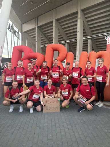 Eine Gruppe von Herder-Mitarbeitenden posiert vor dem Startschild des B2Run