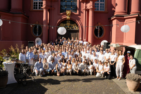 Alle Herder-Mitarbeitenden posieren in einem Gruppenbild vor dem Roten Haus