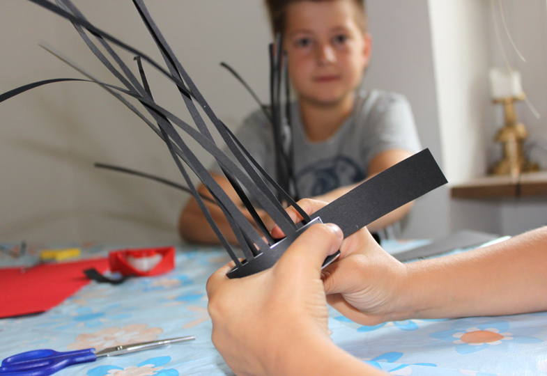 Teelicht mit einem breiten, schwarzen Streifen Tonpapier umwickeln