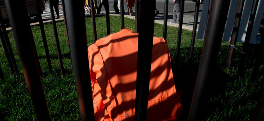 Ein Gefängnisanzug, so wie er in amerikanischen Gefängnissen getragen wird, liegt hinter Gittern als Teil einer Kunstinstallation gegen die Todesstrafe am 5. April 2017 in Washington. Menschen laufen daran vorbei.