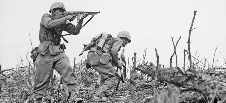 Das schwarzweiß Foto sagt zwei Soldaten. Der eine hat ein Gewehr im Anschlag, während der andere sich neben ihm duckt.