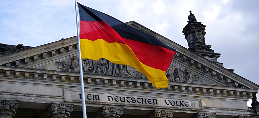 Vor dem Eingang des deutschen Reichstags weht eine Deutsche Flagge.