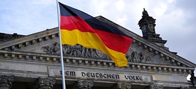Vor dem Eingang des deutschen Reichstags weht eine Deutsche Flagge.