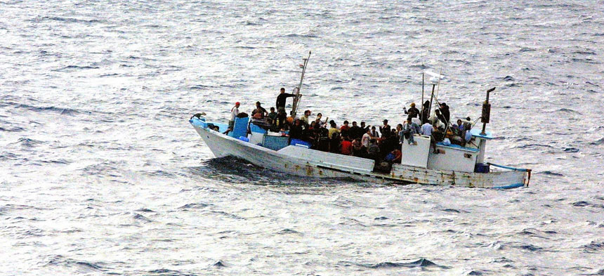 Ein kleines überfülltes Motorboot fährt über das Meer.
