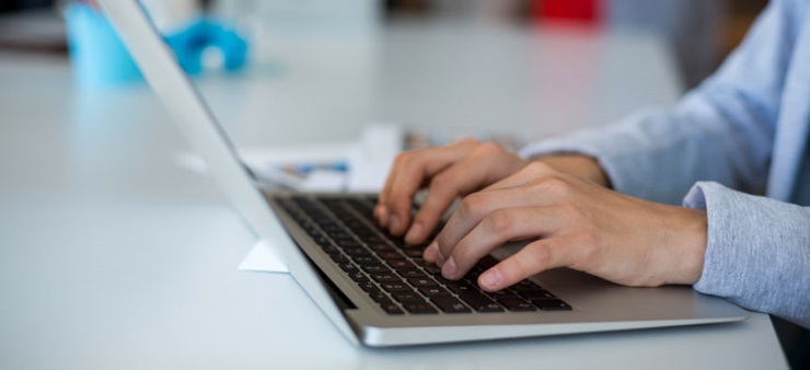 Hände tippen auf Laptop