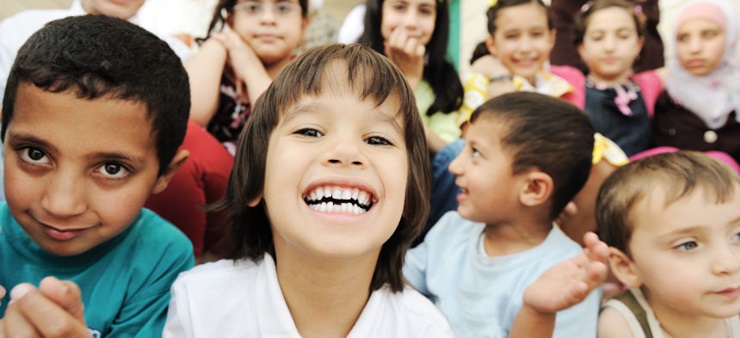 Viele Kinder von verschiedenen Ethnien lächeln in die Kamera.
