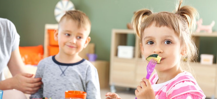 Kinder essen gemeinsam am Tisch.
