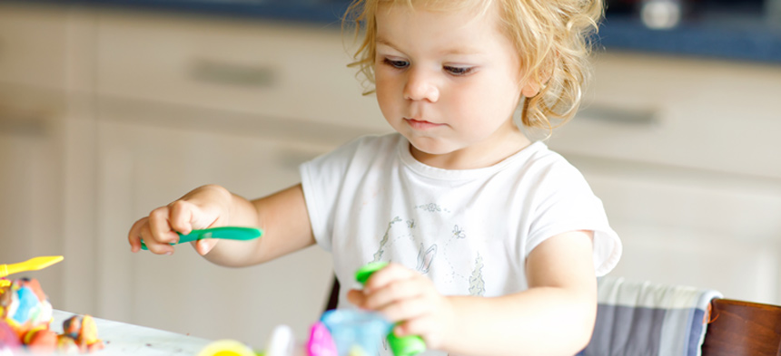 Kind spielt mit bunten Plastikfiguren.