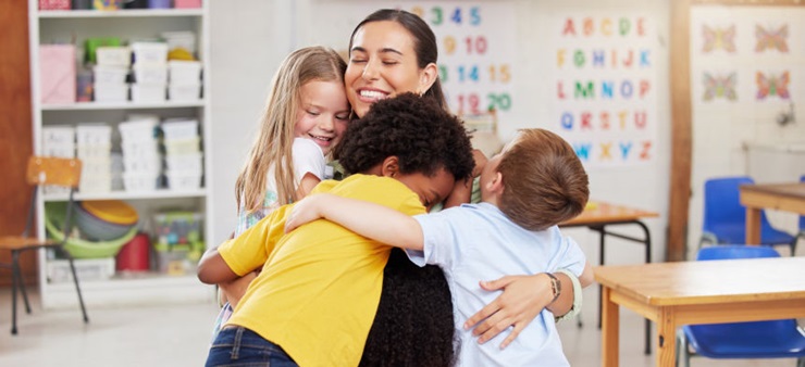 Mehrere Kinder und eine Frau umarmen sich gemeinsam.