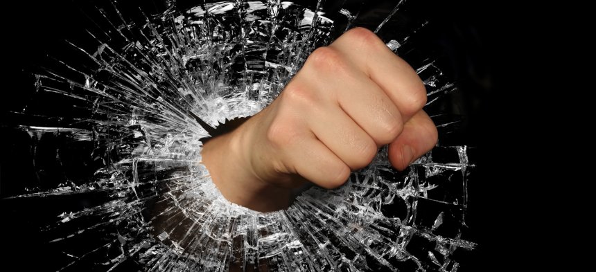 Eine Faust durchbricht eine Glasscheibe
