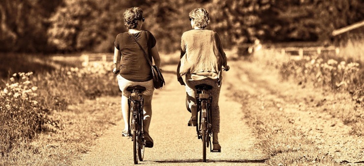 Zwei Frauen fahren nebeneinander her auf dem Rad