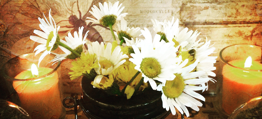 Ein Blumenstrauss und Kerzen.
