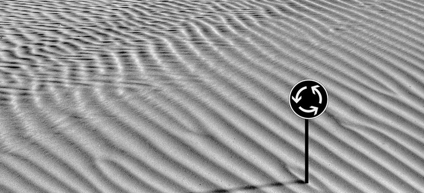 Ein Strassenschild im Sand.