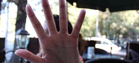 Eine Frau streckt ihre Hand der Kamera entgegen, so dass man ihr Gesicht nicht sehen kann.