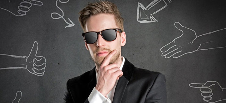 Ein junger Mann mit Sonnenbrille schaut selbstbewusst in die Kamera.