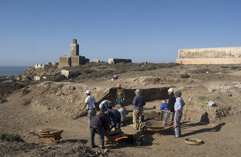 Abb. 7 Eine Gruppe Männer gräbt in der phönizischen Ansiedlung auf der Insel Mogador (Marokko), im Hintergrund das Meer. Die Insel diente phönizischen Seefahrern ab dem 7. Jh. v. Chr. als saisonaler Warenaustauschplatz zwischen der afrikanischen Westküste und Südspanien.
