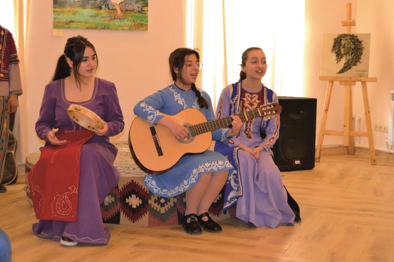 Drei Jugendliche spielen Gitarre und singen.