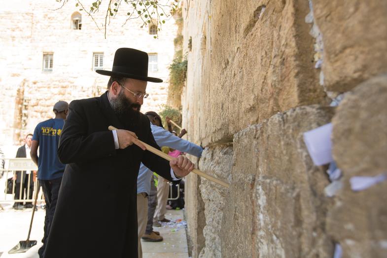 Rabbiner Schmuel Rabinowitsch und seine Mitarbeiter holen Zettel mit Bitten aus der Klagemauer.