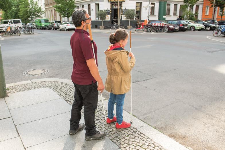  Juan Ruiz mit einem sehbehinderten Kind an einer Straßenkreuzung