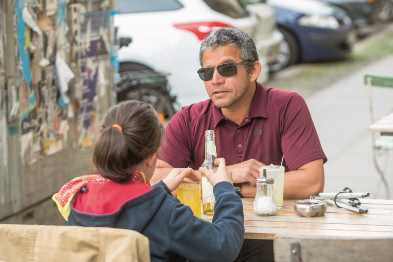 Juan Ruiz sitzt mit der zehnjährigen Violet in einem Café