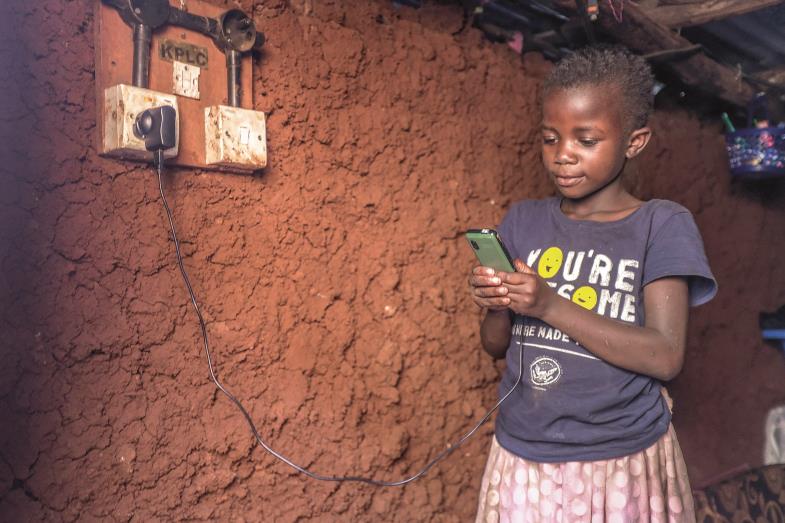 Die neunjährige Ann überprüft im Kibera-Slum von Nairobi, ob das Handy ihrer Mutter geladen ist. Stromausfälle sind häufig, Stromanschlüsse noch selten.