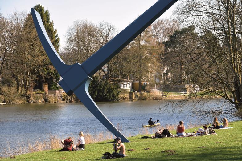 Gäste haben es sich neben der riesigen Spitzhacke des Künstlers Claes Oldenburg gemütlich gemacht. (Foto: Picture alliance/Uwe Zucchi)