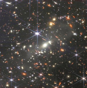Die aus Infrarot-Aufnahmen erstellten Bilder des James-Webb-Teleskops reichen zum Teil sehr weit zurück in die Geschichte des Universums. Hier sind in der „Ferne“ Galaxien sichtbar gemacht, deren Strahlung, die uns jetzt erreichte, vor etwa 13 Milliarden Jahren ausgesendet wurde, also ungefähr 800 Millionen Jahre nach dem „Urknall“, der Geburt unseres Kosmos. (Foto: NASA)