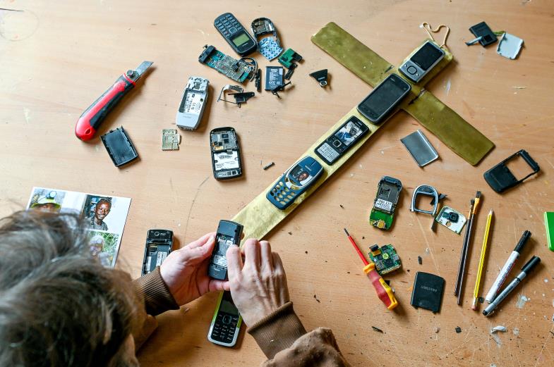 Kreuz für das digitale Zeitalter aus weggeworfenen Handys und Messing aus ausrangierten Klimaanlagen