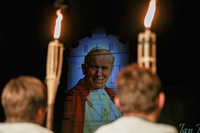 Milde lächelt Papst Johannes Paul II. von einer Hausfassade