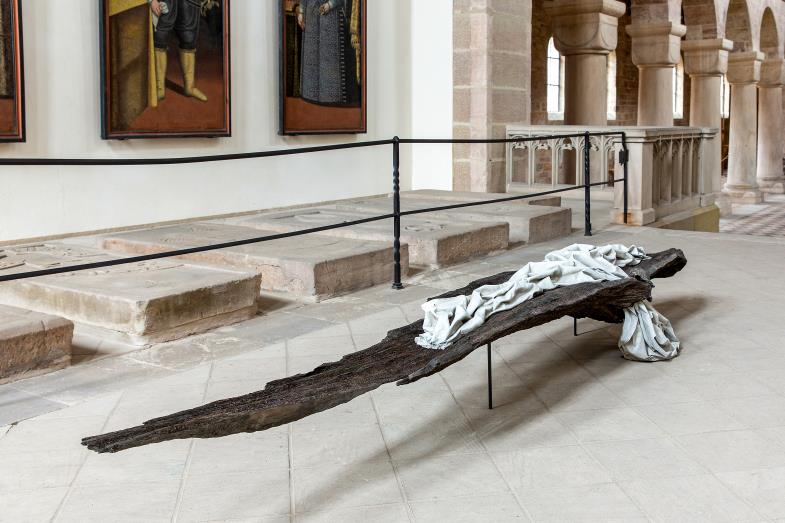 Annette Zappe hat sich von der Ostergeschichte im Johannesevangelium für ihre Arbeit „Transitus“ inspirieren lassen: eine fast 3,5 Meter lange Mooreiche, auf die ein Tuch geworfen scheint.
