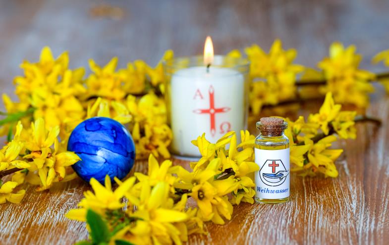 Osterkerze, Weihwasser und Osterei mit Forsythien  (Foto: KNA-Bild)