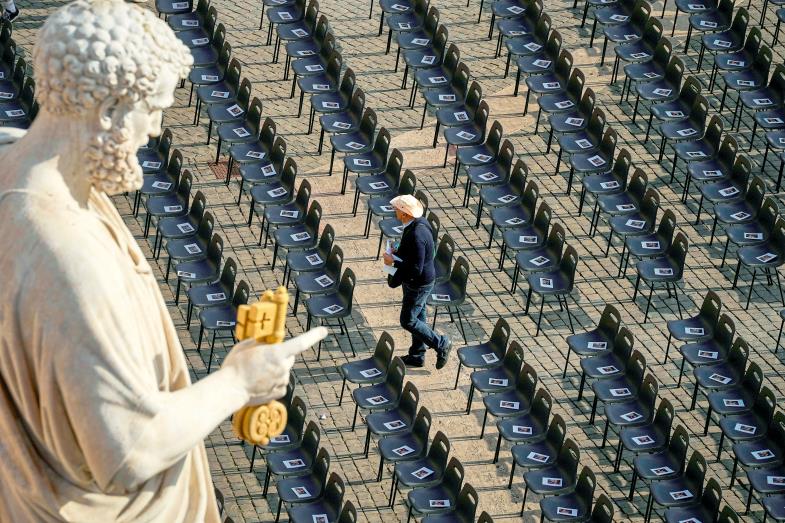 Einzelner Mensch zwischen leeren Stuhlreihen vor der Totenmesse für Papst Franziskus