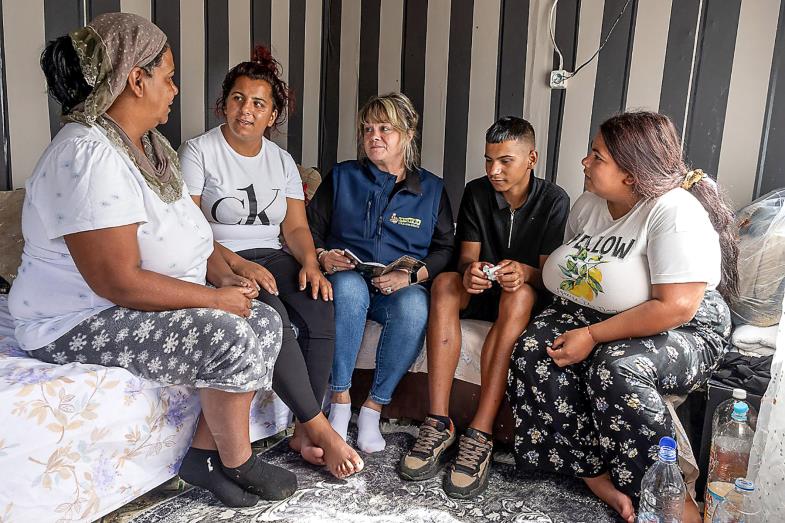 Eine bulgarische Roma-Familie sitzt in einem Kreis mit einer Sozialarbeiterin