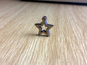 Metallener Fünfstern, oben angefügt eine Rundung, um eine Kette hindurchzuführen