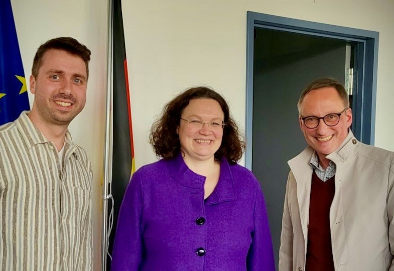 Gruppenbild mit Moritz Findeisen, Andrea Nahles und Achim Budde vor einer Europaflagge