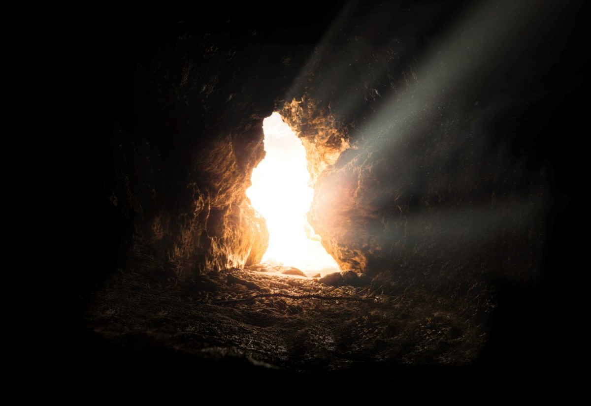 Sonnenstrahlen, die durch den Eingang in eine Höhle/Grab hineinleuchten