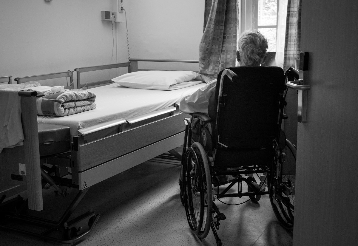 Alte Person in einem Rollstuhl in einem Krankenhauszimmer