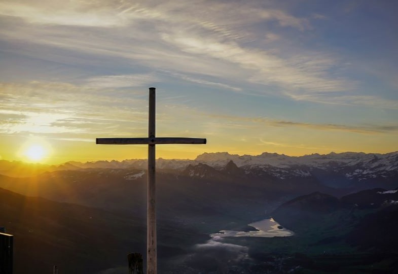 Kreuz vor alpinem Hintergrund
