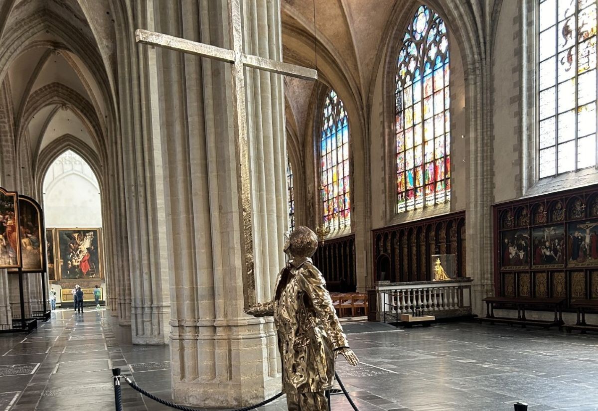 Jan Fabre, Der Mann, der das Kreuz trägt, in der Liebfrauenkathedrale Antwerpen, mit direkter Fluchtlinie auf Rubens' Kreuzabnahme. Rechts befinden sich Kreuzwegstationen von Louis Hendrix und Frans Vinck (1864/68).