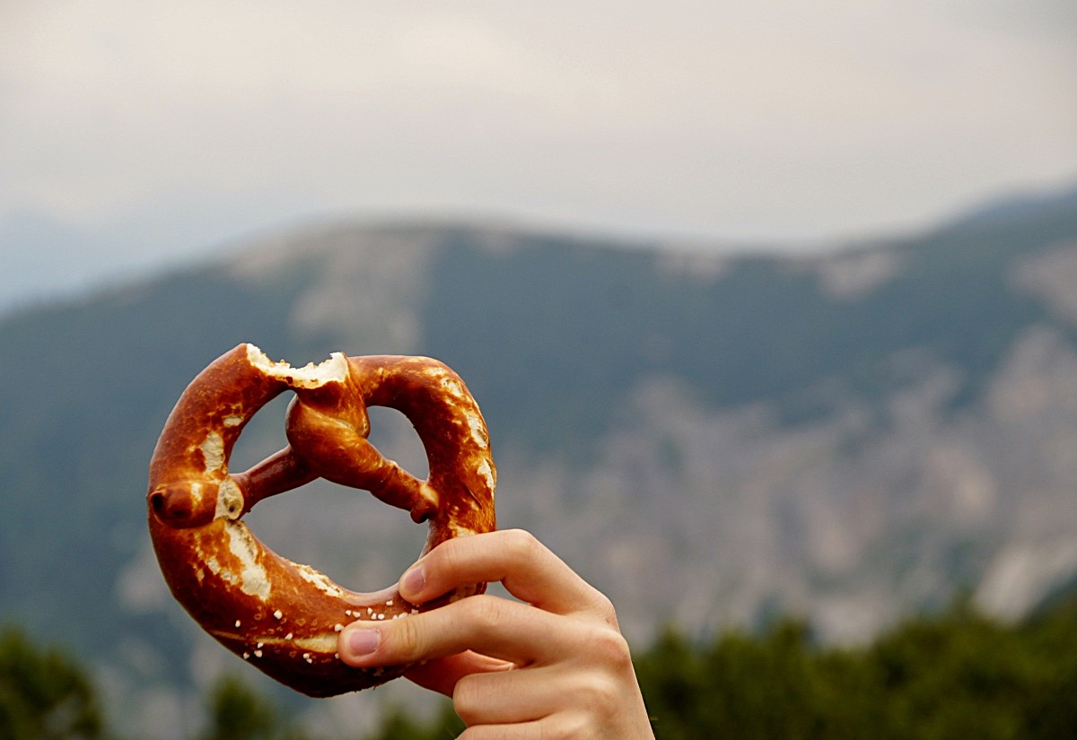Hand, die eine Brezel in die Höhe hält