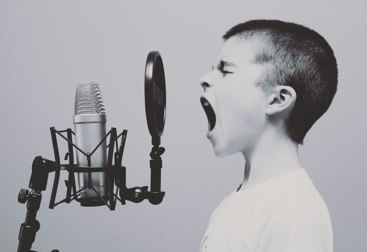 Junge singt in ein Mikrofon
