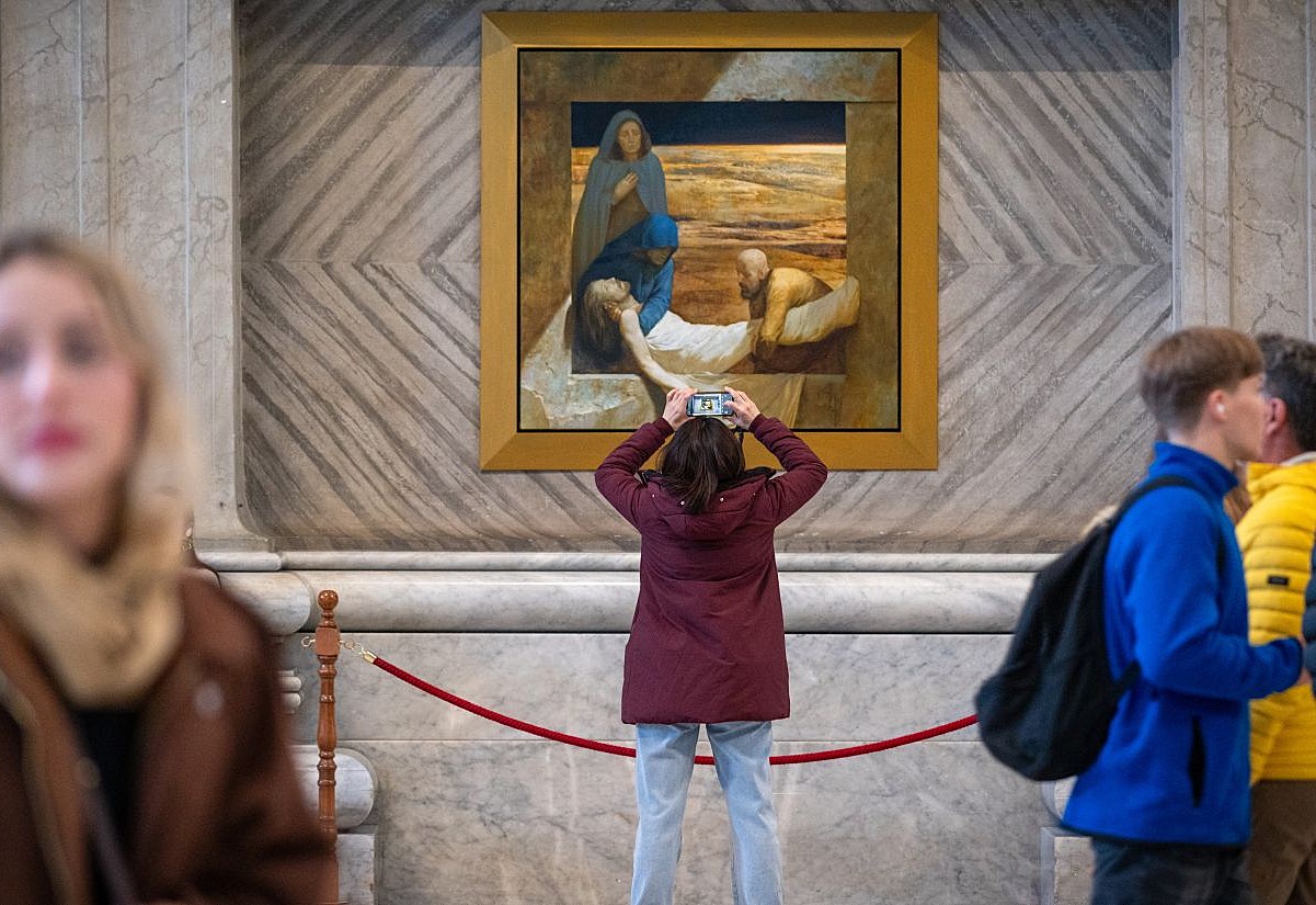 Besucher betrachten am 20. Februar 2026 Kreuzweg-Bilder, gemalt vom Schweizer Künstler Manuel Andreas Dürr, eine Ausstellung zur Fastenzeit im Petersdom im Vatikan.