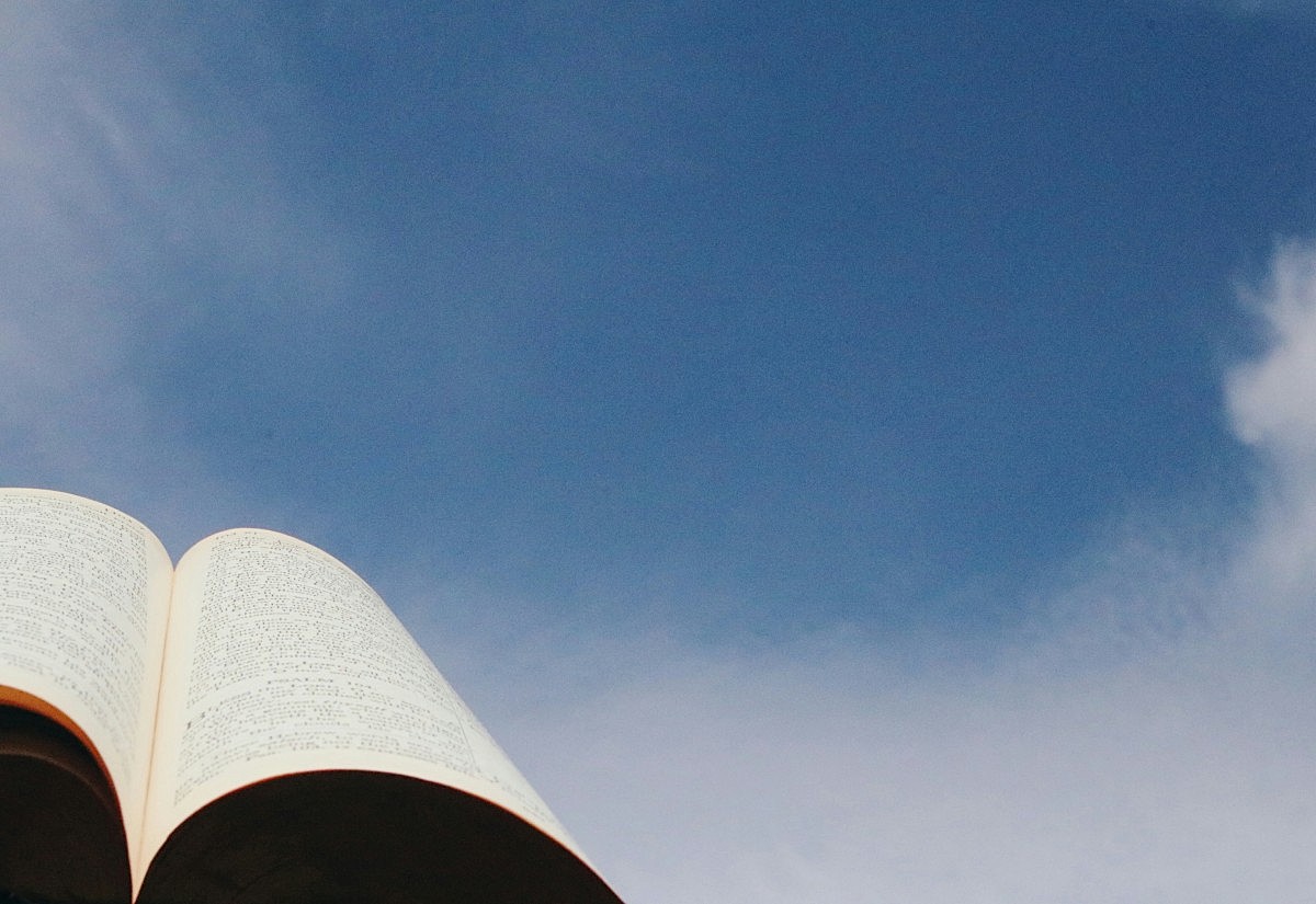 Aufgeschlagene Bibel vor Himmel