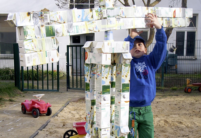 Kind mit Figur aus Recyclingmaterial