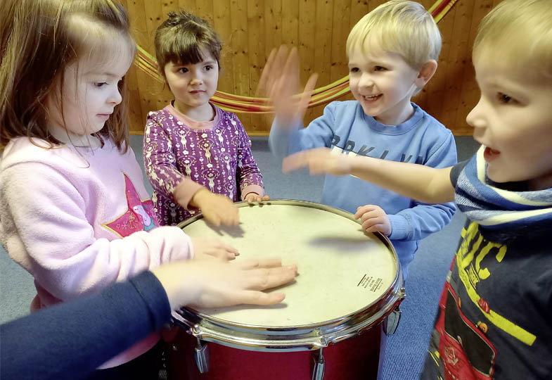 Kinder schlagen auf eine Trommel