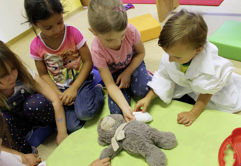 Kinder verarzten einen Teddybären