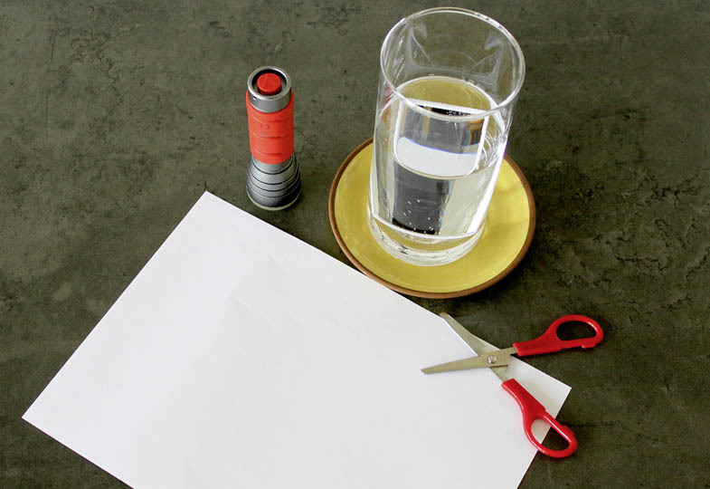 Schere, Papier, Glas mit Wasser, Taschenlampe