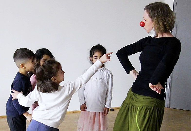 Erwachsene Person mit Clownsnase und Kinder