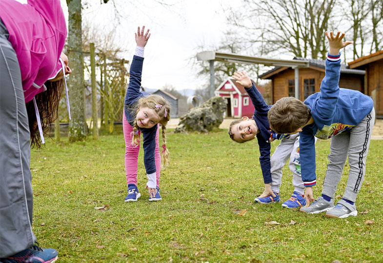 Kinder bewegen sich im Garten