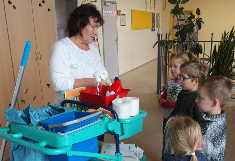 Reinigungsmittel, Lappen, Handschuhe, Müllbeutel – die Kinder erfahren von einer Putzfrau, welche Materialien der Reinigungswagen beinhaltet